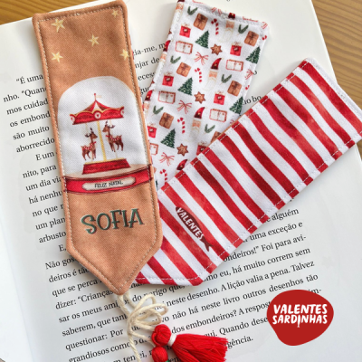 Três fitas natalinas em tecido colorido sobre livro aberto