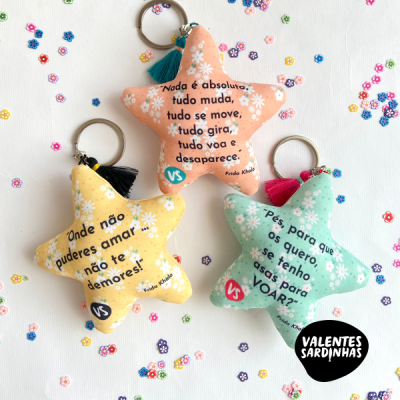 Porta-chaves de tecido em forma de estrela com mensagens em português e padrão floral colorido.