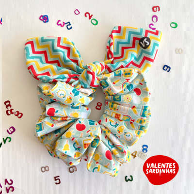 Elástico de cabelo colorido com padrões zig-zag e ícones escolares em fundo branco com letras e números coloridos