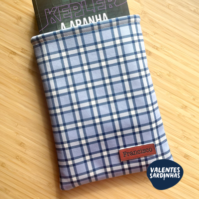 Capa azul e branca xadrez com etiqueta nome 'Francisco' cobrindo livro 'KEPLER A ARANHA'.