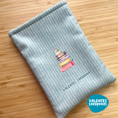 Capa de tecido azul claro com riscas, ilustração de livros e cacto, texto VALENTES SARDINHAS