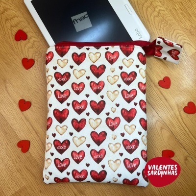 Bolsa pequena com padrão de corações e palavras Love e XOXO, junto a tablet fnac e corações vermelhos pequenos