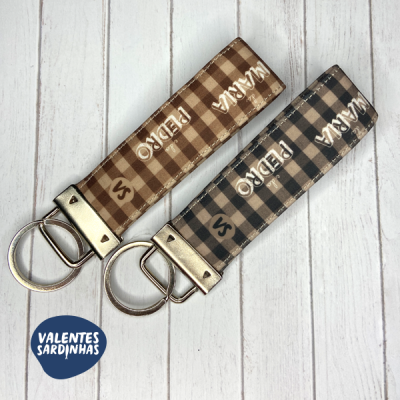 Dois porta-chaves em tecido xadrez castanho e cinza com inscrição MARIA PEDRO S