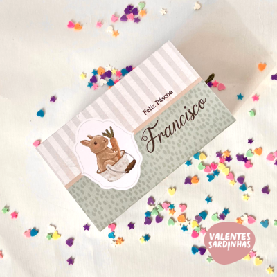 Cartão de Páscoa com coelho e texto 'Feliz Páscoa Francisco' sobre fundo cinza às riscas com confetis coloridos