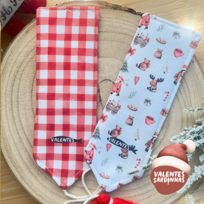 Dois marcadores de páginas em tecido com padrões variados sobre madeira redonda