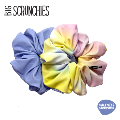 Dois scrunchies grandes em tecido, um lilás e outro em degradê colorido, com etiqueta 'VALENTES'.