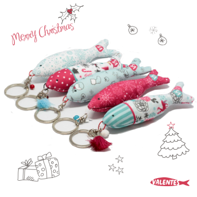 Chaveiros decorativos em forma de peixe com padrões natalícios em várias cores.