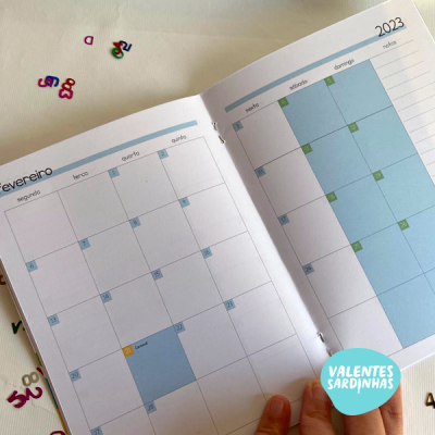 Agenda 2023 aberta nos meses de fevereiro e março com fundo branco e letras coloridas ao redor