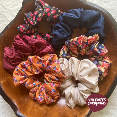 Seis scrunchies coloridos em tigela de madeira com selo VALENTES SARDINHAS
