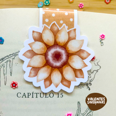 Marcador de página em forma de flor castanha em livro aberto