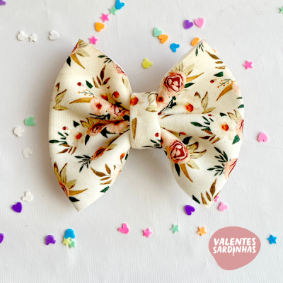 Laço floral branco com confetis coloridos e texto VALENTES SARDINHAS