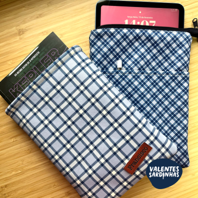 Duas capas de tablet xadrez azul e branco com etiquetas, tablet e fundo madeira