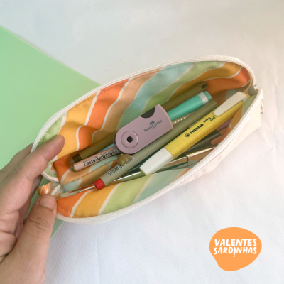 Estojo branco com forro listrado colorido e material de escrita dentro