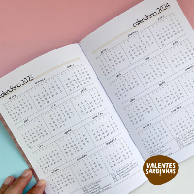 Calendário de bolso aberto com os anos 2023 e 2024, texto em português e selo 'VALENTES SARDINHAS'.