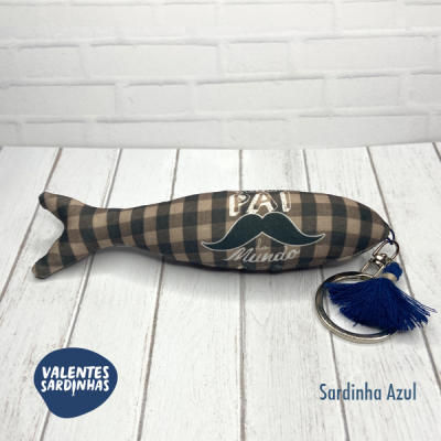 Brinquedo sardinha de tecido xadrez castanho e preto com texto e porta-chaves azul
