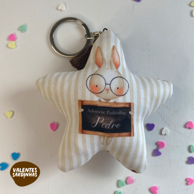 Chaveiro estrela de pelúcia com coelho e texto em português, rodeado por corações de várias cores.