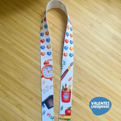Fita branca com estampas coloridas de objetos escolares sobre madeira clara e logótipo VALENTES SARDINHAS