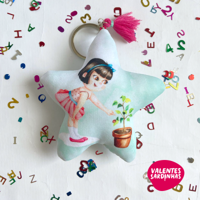 Porta-chaves estrela com ilustração de menina e planta, borla rosa e letras coloridas ao redor