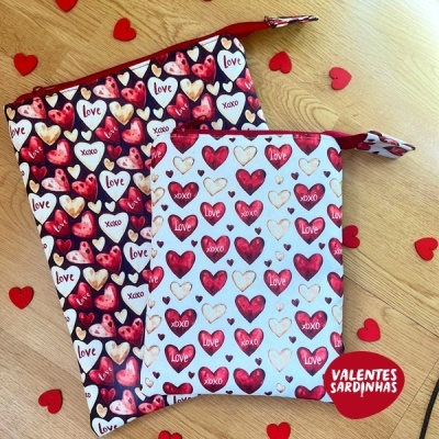 Bolsas com padrão de corações e texto love e xoxo sobre fundo de madeira com corações vermelhos