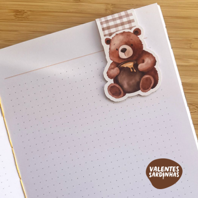 Caderno com autocolante de urso castanho segurando pote de mel e selo VALENTES SARDINHAS