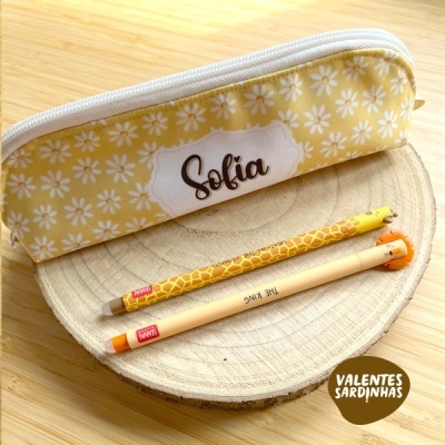 Estojo amarelo com flores brancas e o nome Sofia, dois lápis decorados, suporte redondo de madeira