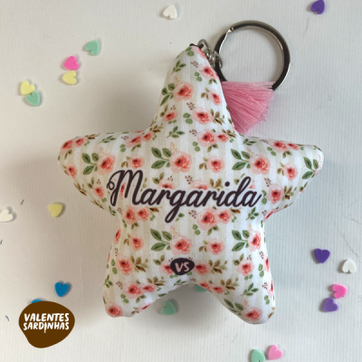 Chaveiro estrela em tecido branco com flores cor-de-rosa e texto Margarida, com anel metálico e penugem rosa