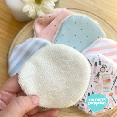 Discos desmaquilhantes reutilizáveis com vários padrões e cores sobre base de madeira clara