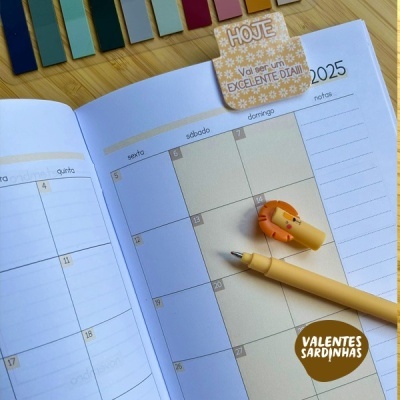 Planner aberto a mostrar calendário de março de 2025 com marcador e caneta sobre uma mesa de madeira.