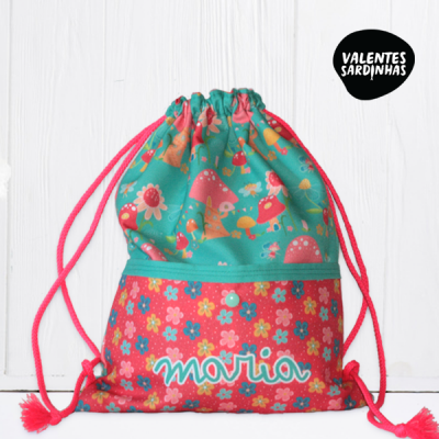 Mochila de cordão colorida com padrão floral e de cogumelos, nome 'maria' bordado