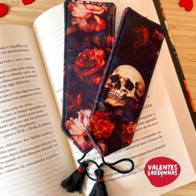 Dois marcadores de livros com crânios e flores, folhas de livro aberto