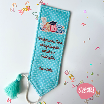 Marcador de livros azul com bolinhas brancas e texto em vermelho para professora Sara