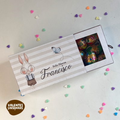Caixa de chocolates decorada com coelho e texto Feliz Páscoa Francisco com bombons visíveis