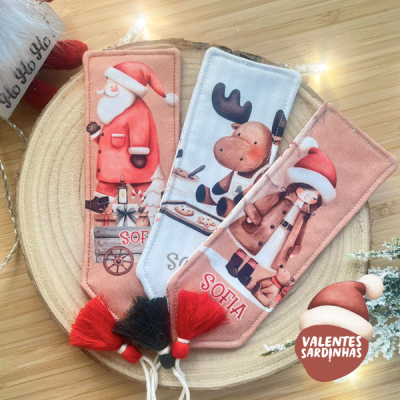 Marcadores de livros natalícios em tecido com desenhos de Pai Natal, rena e menina, e texto 'SOFIA' e 'VALENTES SARDINHAS'