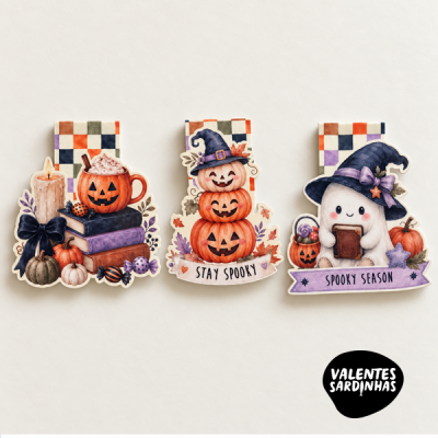 Três porta-notas de papel decorados com motivos de Halloween em cores quentes e fundo xadrez.