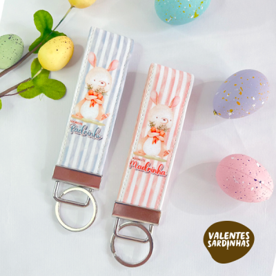 Dois porta-chaves com coelhos e fundos às riscas azul e rosa, em fundo branco com ovos de Páscoa coloridos