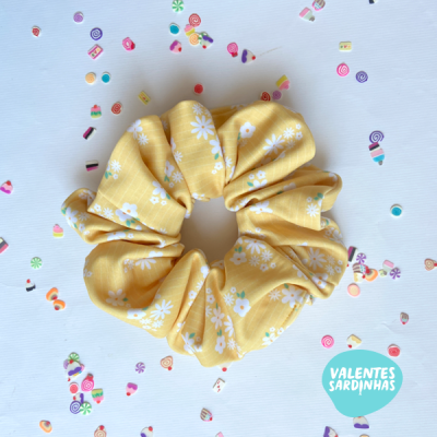 Elástico de cabelo amarelo com flores brancas e confetes coloridos sobre fundo branco