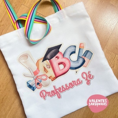 Saco branco com alças arco-íris e estampa colorida com texto Professora Zé