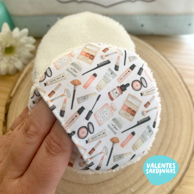 Disco desmaquilhante reutilizável com padrão de produtos cosméticos sobre superfície de madeira.