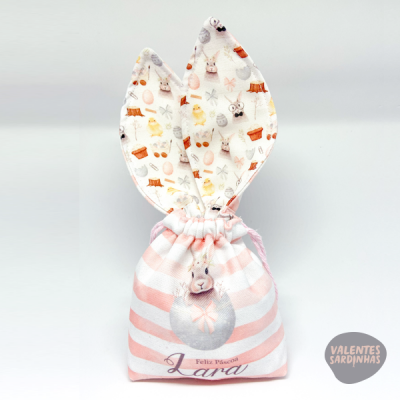 Saco de tecido riscado rosa e branco com orelhas de coelho e texto Feliz Páscoa Lara