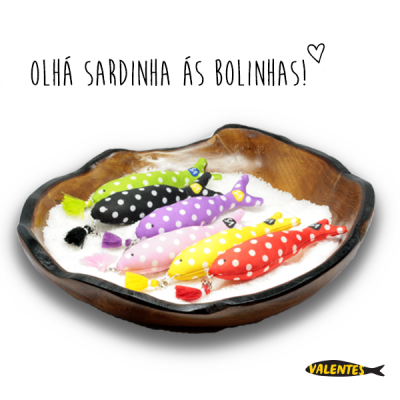 Cinco sardinhas decorativas às bolinhas numa travessa de madeira com sal