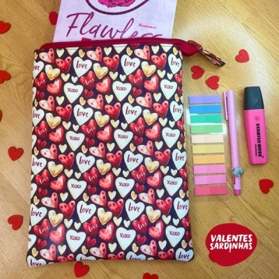 Bolsa com padrão de corações e palavras Love e Xoxo, caneta rosa, post-its coloridos, marcador rosa e cartão com texto Flawless sobre mesa de madeira.