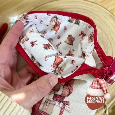 Bolsa pequena com padrão natalício, fecho vermelho e etiqueta VALENTES SARDINHAS.