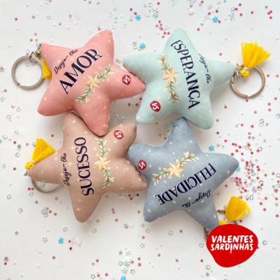 Porta-chaves em forma de estrela em diferentes cores com textos AMOR, ESPERANÇA, SUCESSO, FELICIDADE
