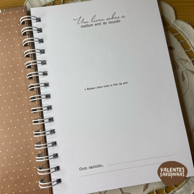 Livro em papel branco com texto em português e encadernação espiral
