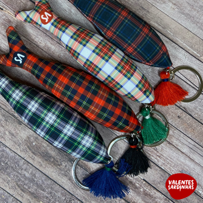 Brinquedos em forma de peixe com padrão xadrez e porta-chaves com borlas coloridas