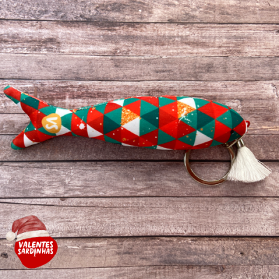 Chaveiro sardinha colorida com padrão geométrico sobre madeira