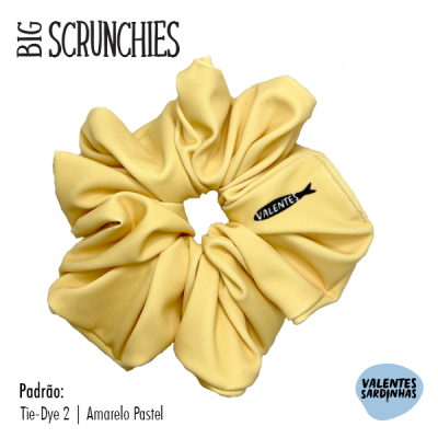 Scrunchie amarelo pastel com etiqueta 'VALENTES' e texto informativo