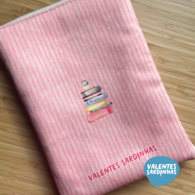 Capa de livro rosa com riscas e ilustração de livros