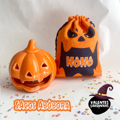 Sacos de tecido alaranjados com estampa de abóbora e abóbora decorativa alaranjada