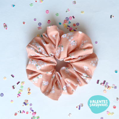 Elástico para cabelo cor de pêssego com flores brancas e confetis coloridos em fundo branco